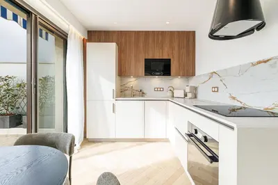 a kitchen with white cabinets and a counter top at Appartement Mamabaldi in Nice