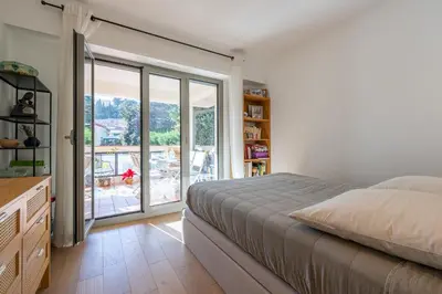a bedroom with a bed and a sliding glass door at flora in Beaulieu-sur-Mer