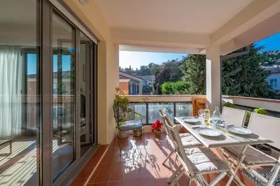 a dining room with a table and chairs on a balcony at flora in Beaulieu-sur-Mer