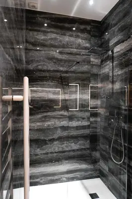 a bathroom with a shower with a black wall at La Verrière du Vieux Nice in Nice