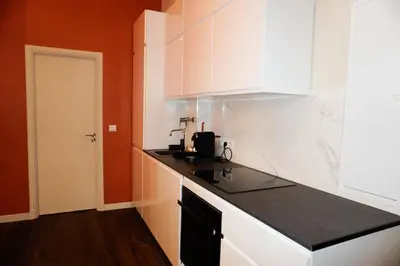 a kitchen with white cabinets and a black counter top at La Verrière du Vieux Nice in Nice