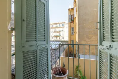 a balcony with green shutters and a view of a city at MY CASA - EMMANUEL - Cozy apartment with Port view in Nice