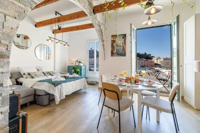 a living room with a bed and a table and chairs at MY CASA - EMMANUEL - Cozy apartment with Port view in Nice