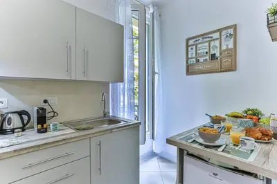 a kitchen with white cabinets and a counter with food on it at GROSSO 1 MD - New 3 minutes from the Sea in Nice