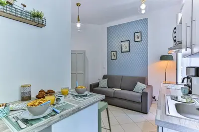 a kitchen and living room with a table and a couch at GROSSO 1 MD - New 3 minutes from the Sea in Nice