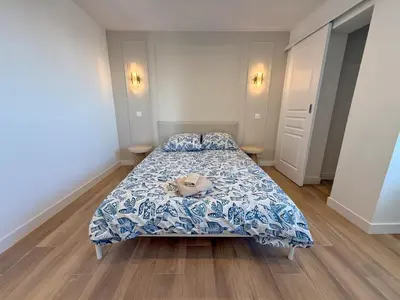 a bedroom with a bed with a blue and white comforter at Nice Ouest Chambres Privees Modernes TV Wifi Bureau in Nice