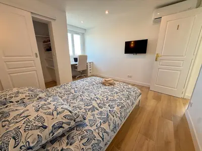 a bedroom with a bed and a tv on the wall at Nice Ouest Chambres Privees Modernes TV Wifi Bureau in Nice