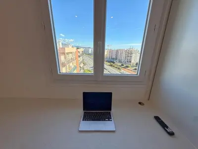 a laptop sitting in a room with a window at Nice Ouest Chambres Privees Modernes TV Wifi Bureau in Nice