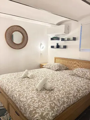 a bedroom with a bed with two pillows and a mirror at T4 Front de mer Piscine interieure privee Clim in Cagnes-sur-Mer