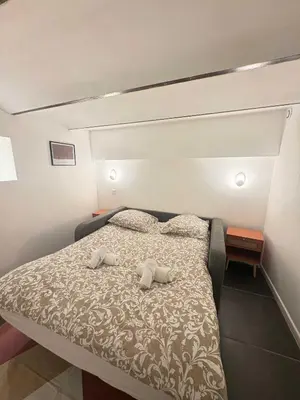 a bedroom with a bed with two pillows on it at T4 Front de mer Piscine interieure privee Clim in Cagnes-sur-Mer