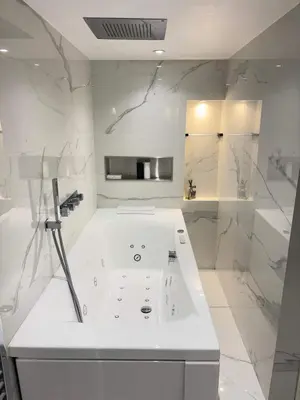 a white bathroom with a tub and a sink at T4 Front de mer Piscine interieure privee Clim in Cagnes-sur-Mer