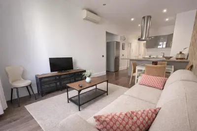 a living room with a couch and a table at RAIMBALDI Urban Gare - Spacieux T3 climatisé au cœur du centre-ville in Nice