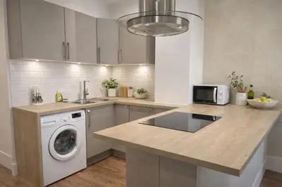 a kitchen with a washer and dryer on a counter at RAIMBALDI Urban Gare - Spacieux T3 climatisé au cœur du centre-ville in Nice