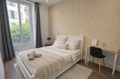a bedroom with a bed and a desk and a window at RAIMBALDI Urban Gare - Spacieux T3 climatisé au cœur du centre-ville in Nice