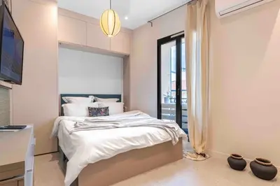 a bedroom with a bed with white sheets and a window at 10 Félix Faure, Nice in Nice