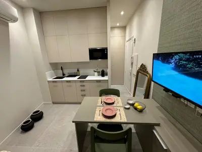 a kitchen with a table and a large screen tv at 10 Félix Faure, Nice in Nice