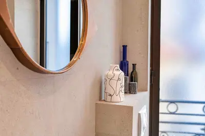 a bathroom with a mirror and some bottles on a shelf at 10 Félix Faure, Nice in Nice