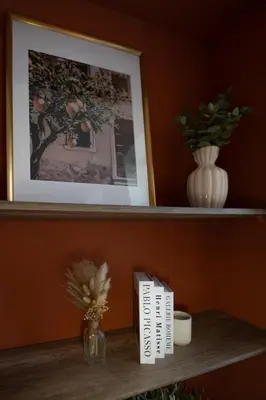 a shelf with a picture and a book and a vase at L'Écrin de la Piétonne in Nice