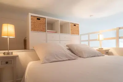 a bedroom with a white bed with two pillows at L'Écrin de la Piétonne in Nice