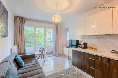 a living room with a couch and a kitchen at Nice 2 pièces proche centre in Nice