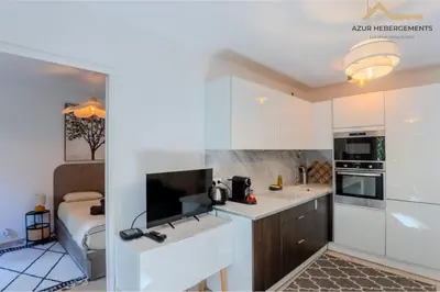a small kitchen with white cabinets and a sink at Nice 2 pièces proche centre in Nice