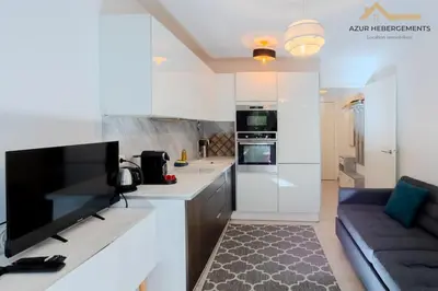 a white kitchen with a couch in a room at Nice 2 pièces proche centre in Nice