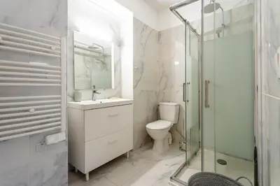 a bathroom with a toilet and a glass shower at Rue Michelet in Nice