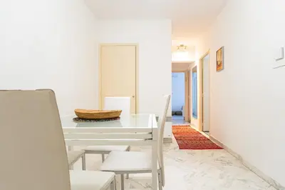 a white dining room with a white table and chairs at Rue Michelet in Nice