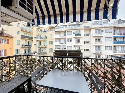 a table and chairs on a balcony with a building at Spacieux 3p Nice Riquier terrasse clim parking in Nice