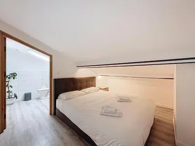 a bedroom with a large white bed with a mirror at Spacieux 3p Nice Riquier terrasse clim parking in Nice