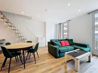 a living room with a green couch and a table at Spacieux 3p Nice Riquier terrasse clim parking in Nice