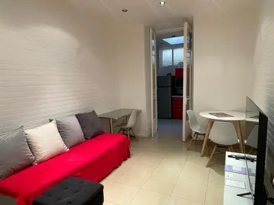 a living room with a red couch and a table at One-Bedroom Apartment near Promenade des Anglais in Nice