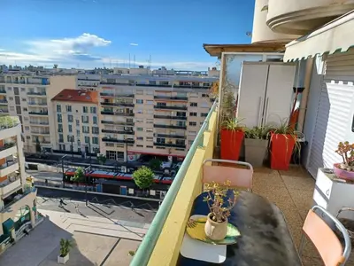 a balcony with a table and a view of a city at L'escale à la French Riviera in Nice