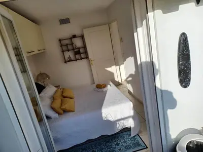 a small bedroom with a bed with yellow pillows at L'escale à la French Riviera in Nice