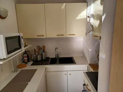 a kitchen with white cabinets and a sink and a microwave at L'escale à la French Riviera in Nice
