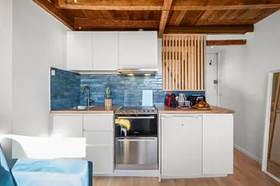 a kitchen with white cabinets and a stainless steel appliance at Le Panoramique - Vieux-Nice in Nice