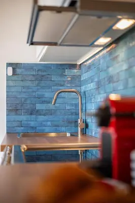 a sink in a kitchen with blue tiles at Le Panoramique - Vieux-Nice in Nice