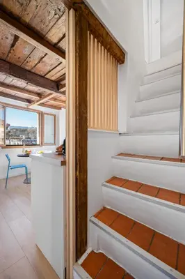 a staircase in a house with white walls and wooden ceilings at Le Panoramique - Vieux-Nice in Nice