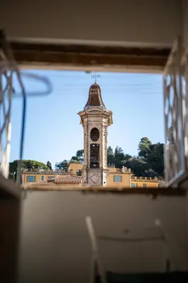 a view of a clock tower through a window at Le Panoramique - Vieux-Nice in Nice