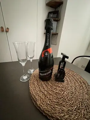 a bottle of wine sitting on a table with two glasses at Bright modern studio, Nice Port, walk to tram and beach! in Nice