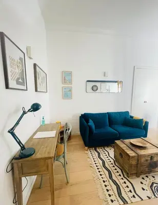 a living room with a blue couch and a table at Bright modern studio, Nice Port, walk to tram and beach! in Nice