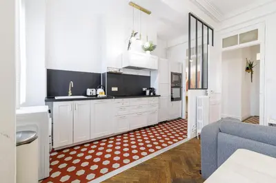 a kitchen with white cabinets and a blue couch at Large 2 Bdr City Center close to Train Station in Nice