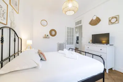 a white bedroom with a bed and a tv at Large 2 Bdr City Center close to Train Station in Nice
