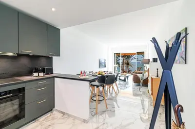 a kitchen with green cabinets and a dining room at PROM 92 - Amazing Sea View 3 rooms with terrace in Nice