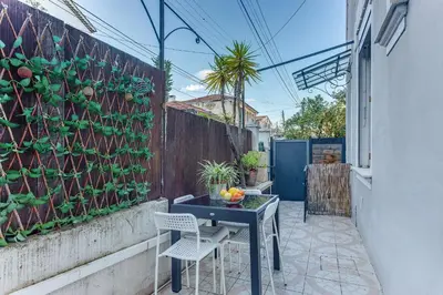 a patio with a table and chairs next to a wall with plants at LE CYRNOS AP4499 By Riviera Holiday Homes in Nice