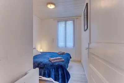a small bedroom with a blue bed and a window at LE CYRNOS AP4499 By Riviera Holiday Homes in Nice