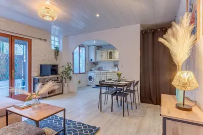 a living room with tables and chairs and a kitchen at LE CYRNOS AP4499 By Riviera Holiday Homes in Nice