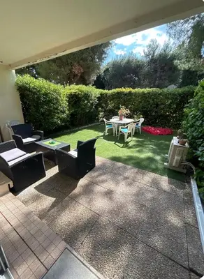 a patio with a table and chairs on the grass at 2 pièces RDJ Proche Mer in Nice