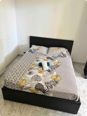 a bed in a bedroom with a black frame at 2 pièces RDJ Proche Mer in Nice