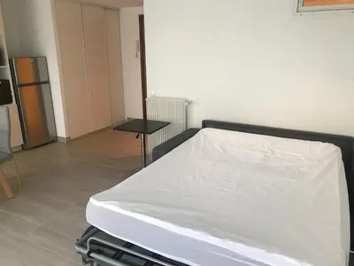 a white bed in a room with a table at Studio Libération Piscine centre ville Nice in Nice